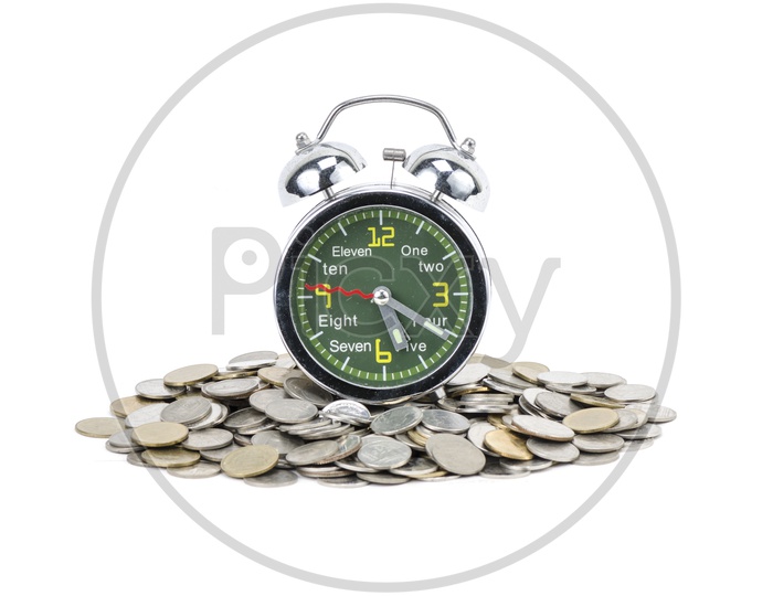 Alarm clock standing with Currency  coins isolated on white background