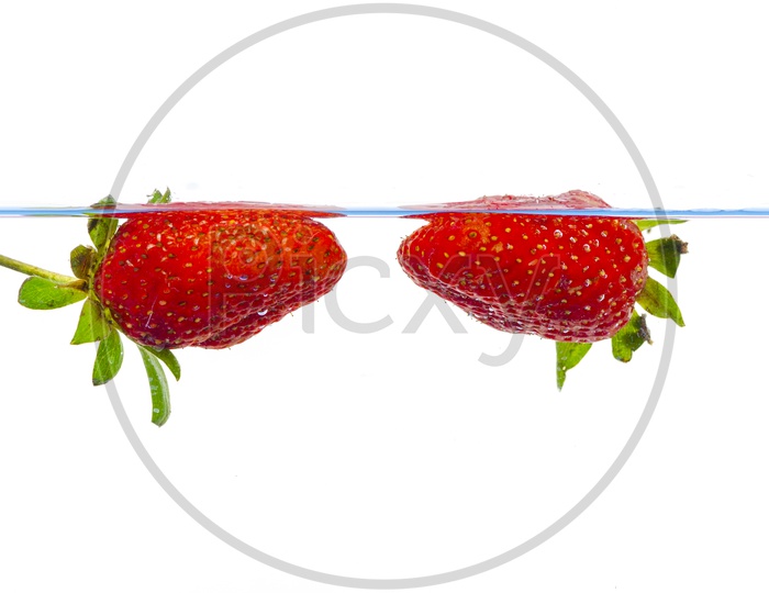 Fresh Strawberries Dropped Into Water With Splash  Over an Isolated White Background