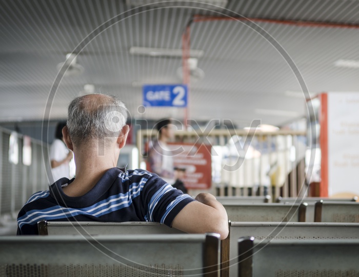 An Old Man Waiting At Passenger Waiting Lounge In an Airport