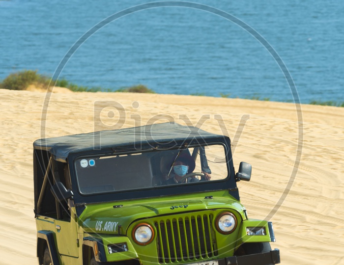 Tourists enjoy in the desert by jeep car in Mui Ne, Vietnam