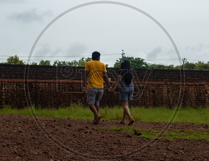 Couple holding hands and walking at Aguada Fort.