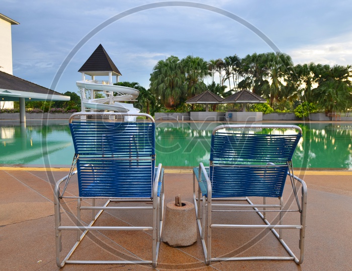 Beach chairs near swimming pool in Thailand tropical resort