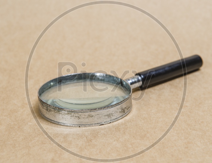 Old magnifying glass on vintage paper background