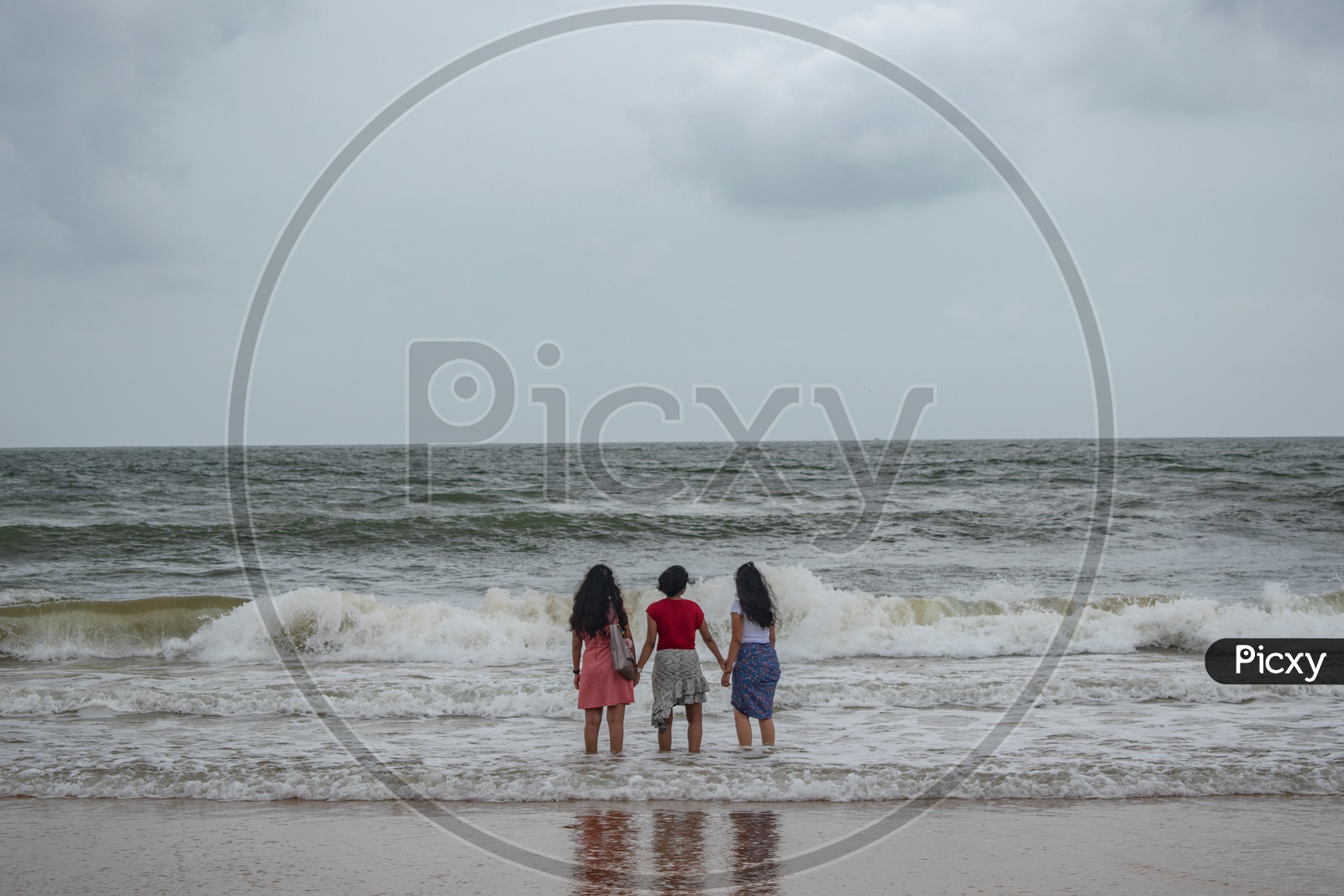 Three girls/women enjoying at Sinquerium Beach Goa, Candolim, Goa, India