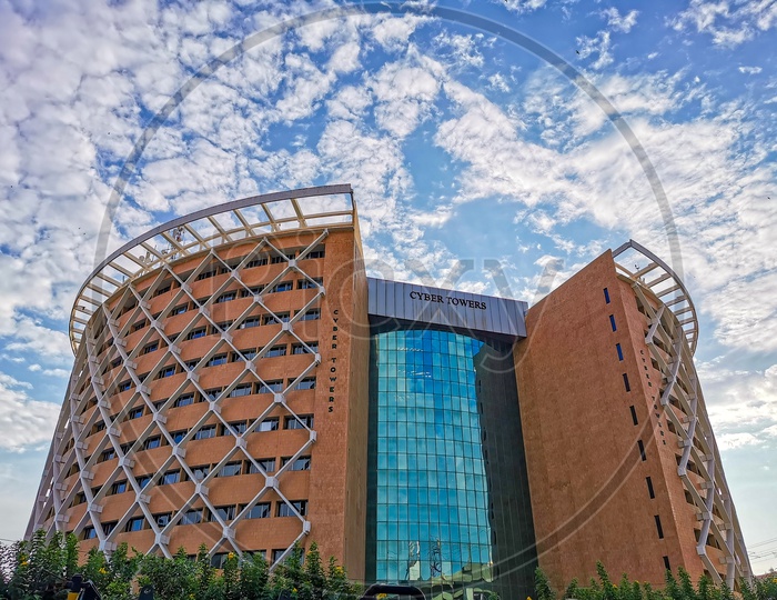 Cyber Towers Facade View With Cotton Clouds and Blue Sky in Background
