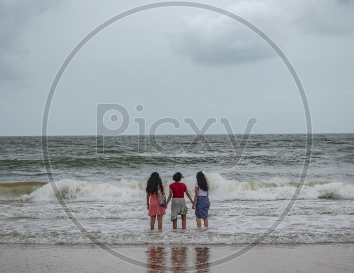 Three girls/women enjoying at Sinquerium Beach Goa, Candolim, Goa, India