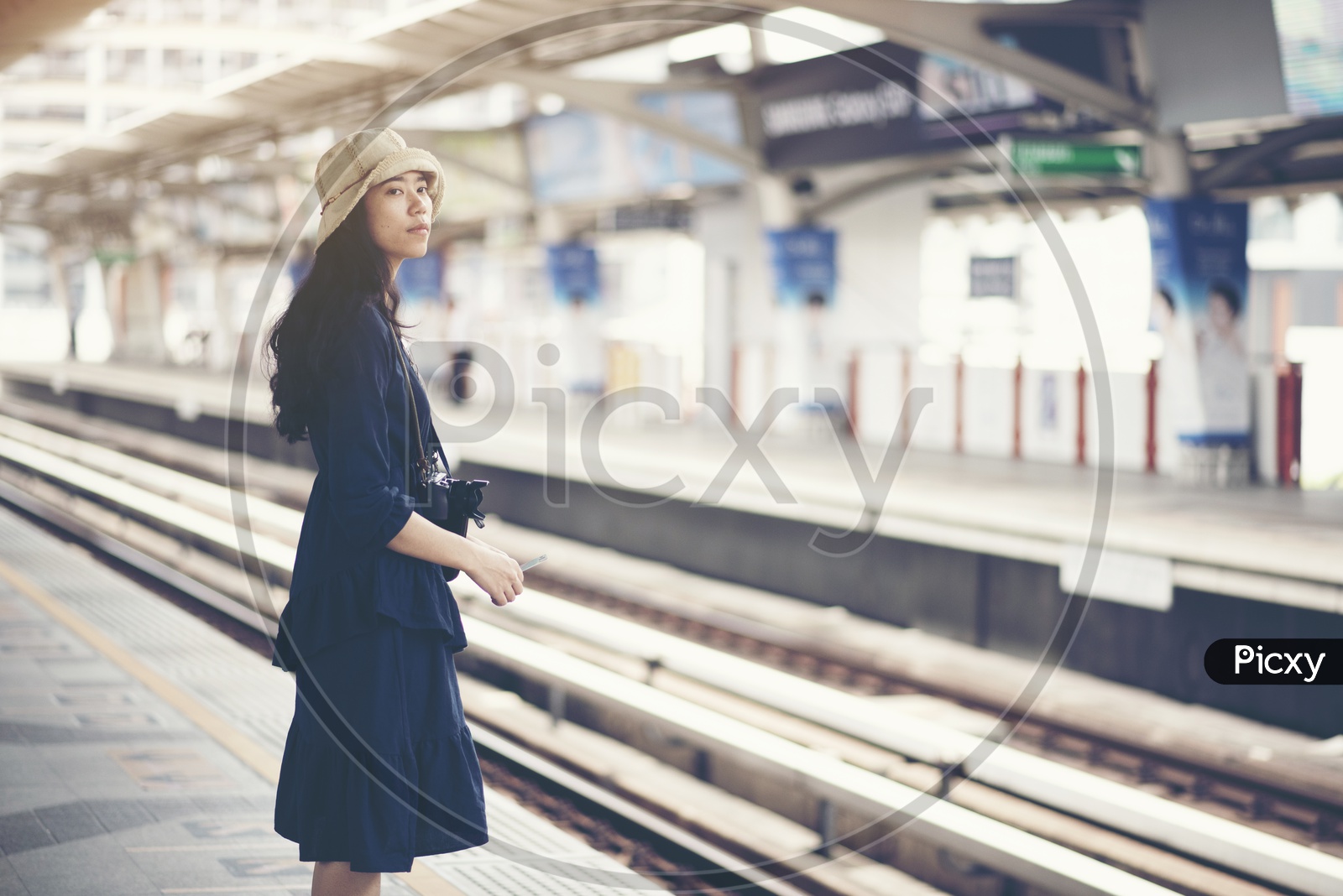 Asian girl waiting train at skytrain station for travel in the big city, lifestyle and transportation concept