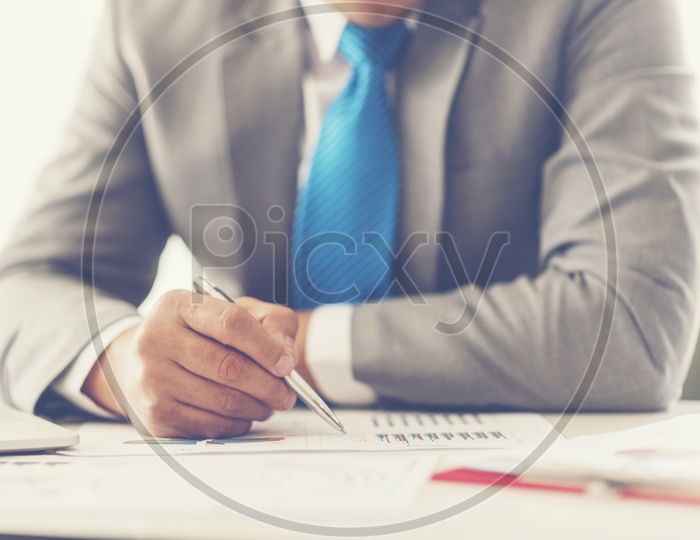 A Business man working at office with laptop and documents on his desk