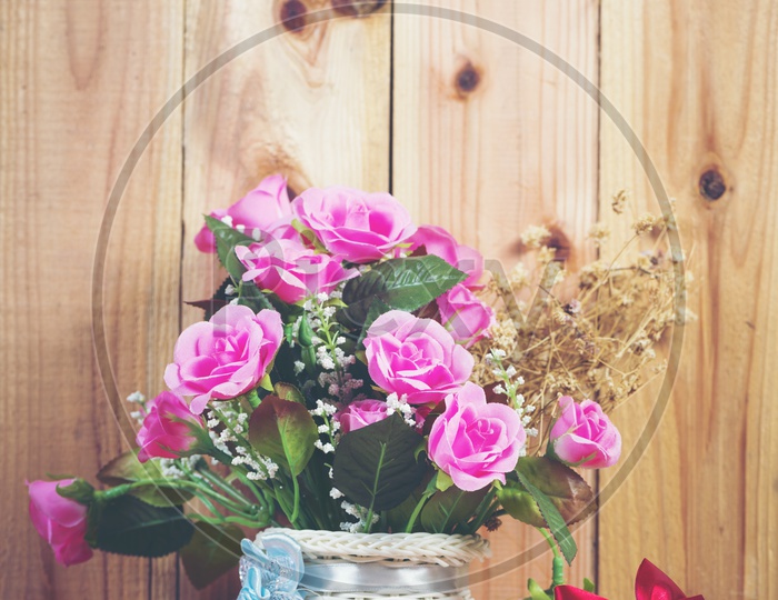 Rose Flowers in a Vase Over an Wooden  Background