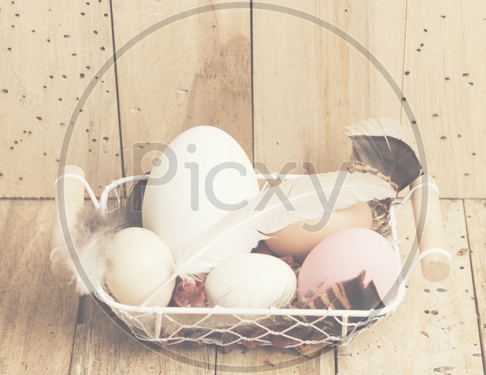 Easter Eggs In a Basket Over an Wooden  Background