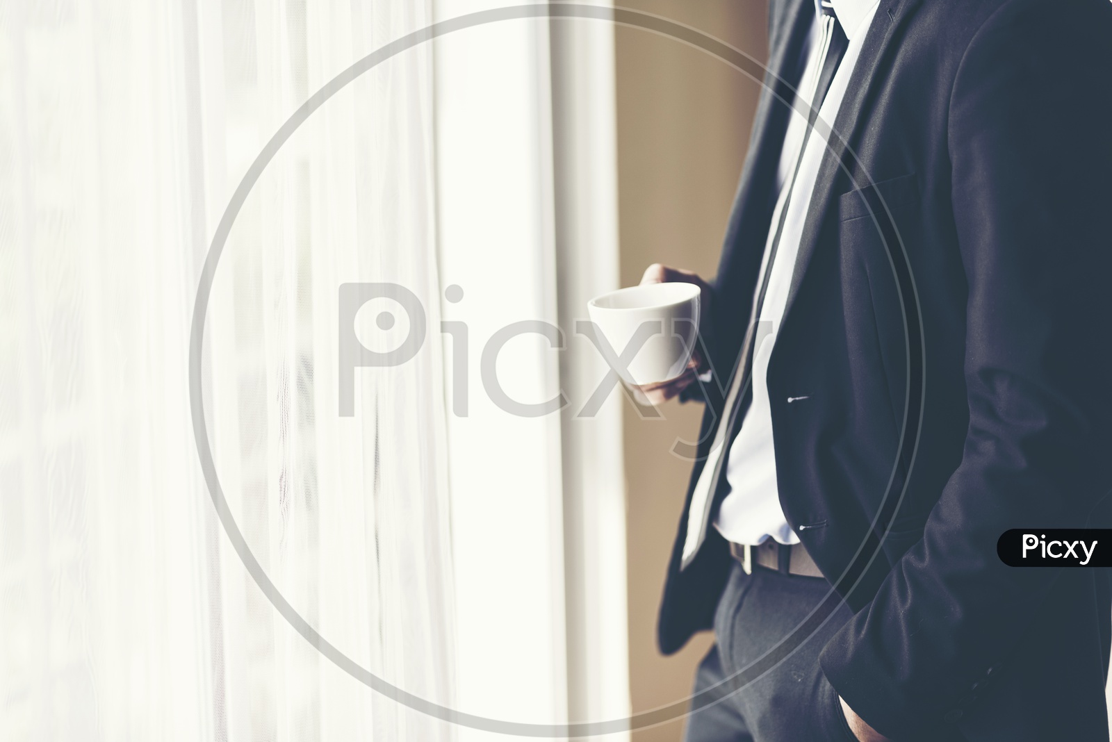 A businessman holding a coffee cup