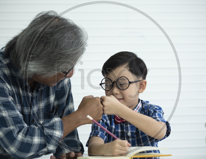 Older teachers are teaching students to do homework, education concept