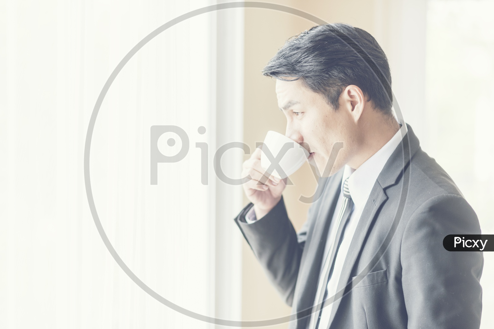 Asian CEO of a company drinking Coffee