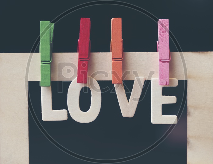 Wooden letters forming word LOVE hung through the clips