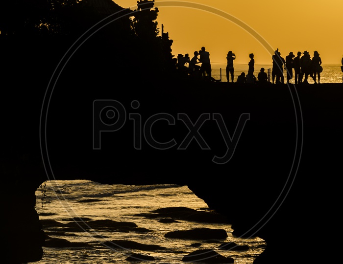 Silhouette of tourists during sunset at Pura Batu Bolong - Tanah Lot, Bali , Indonesia