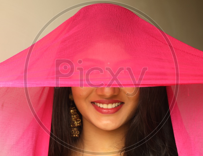 Indian Woman smiling covering her face with scarf