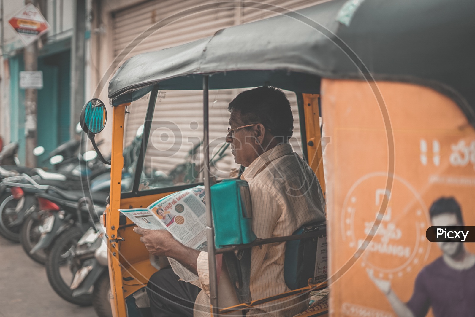 Hyderabad auto driver reading a news papaer