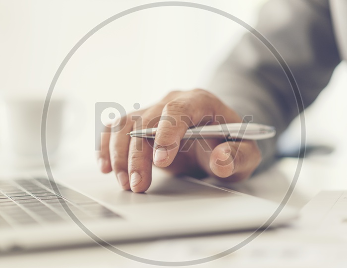 Close-up of male hands using laptop at office,