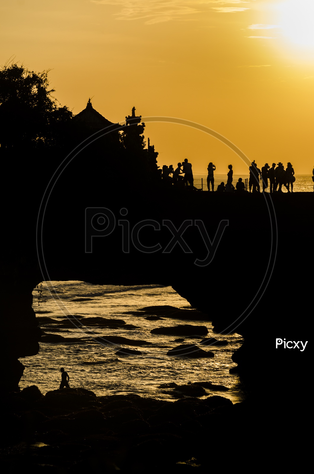 Silhouette of tourists during sunset at Pura Batu Bolong - Tanah Lot, Bali , Indonesia