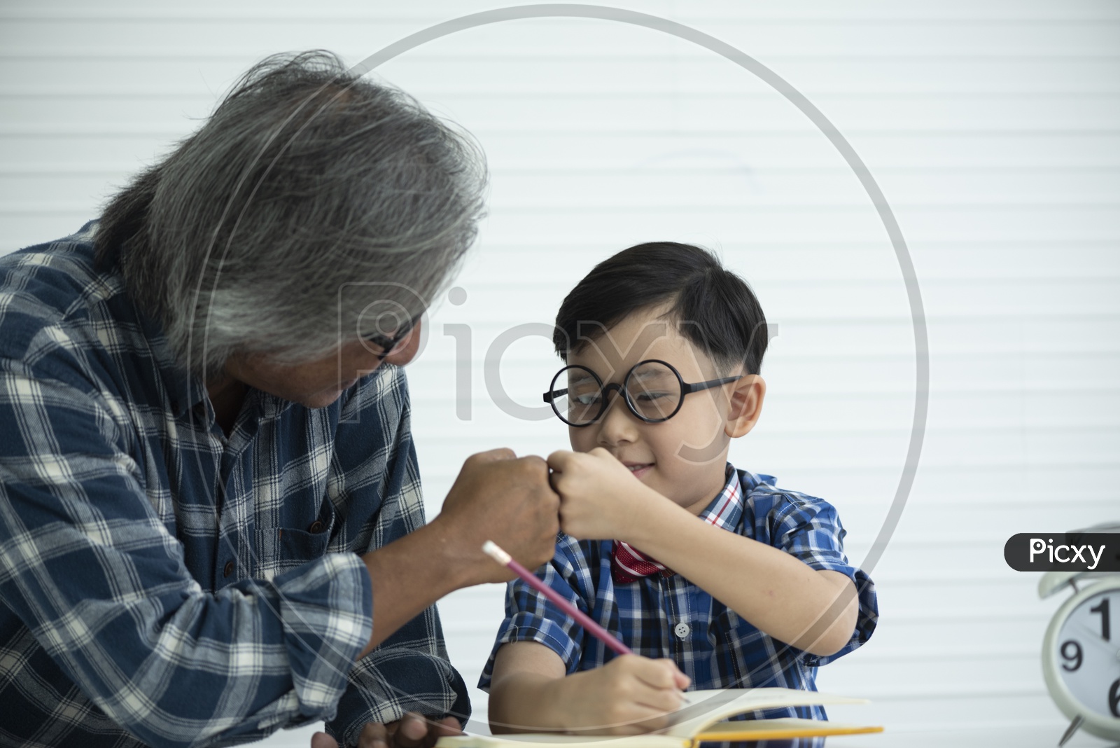 Older teachers are teaching students to do homework, education concept