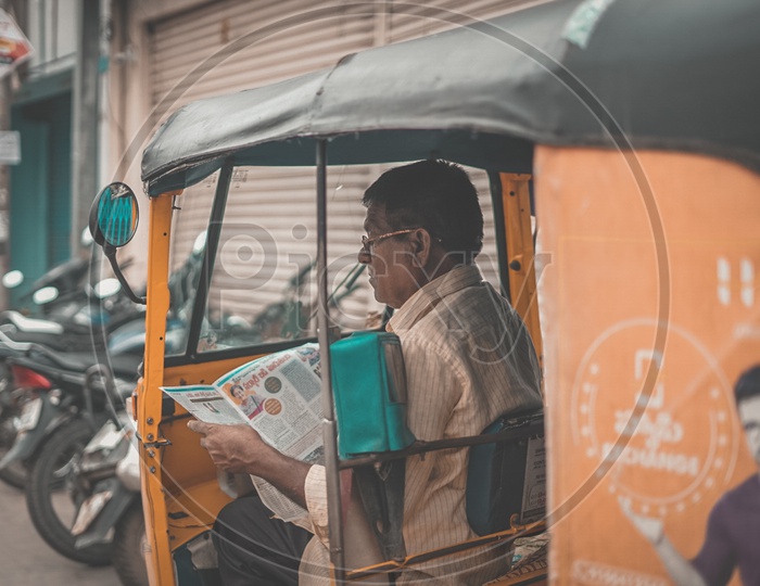 Hyderabad auto driver reading a news papaer
