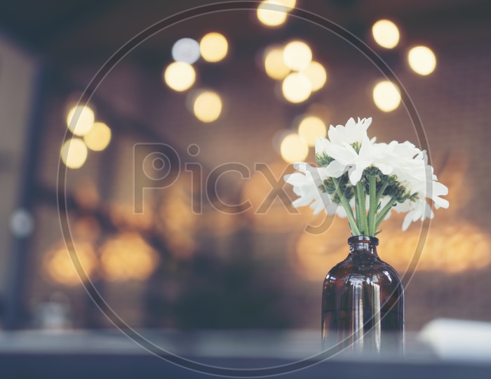 Flower Vase on a Cafe Table Background With Light Bokeh
