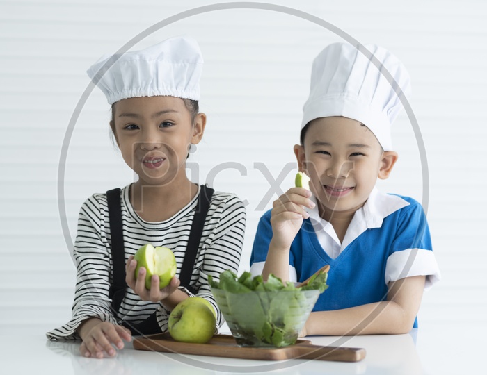boy and girl with green apple in hands, kitchen concept