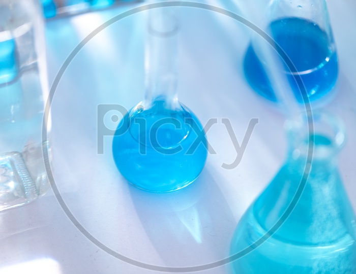 Different laboratory glassware with color liquid and with reflection