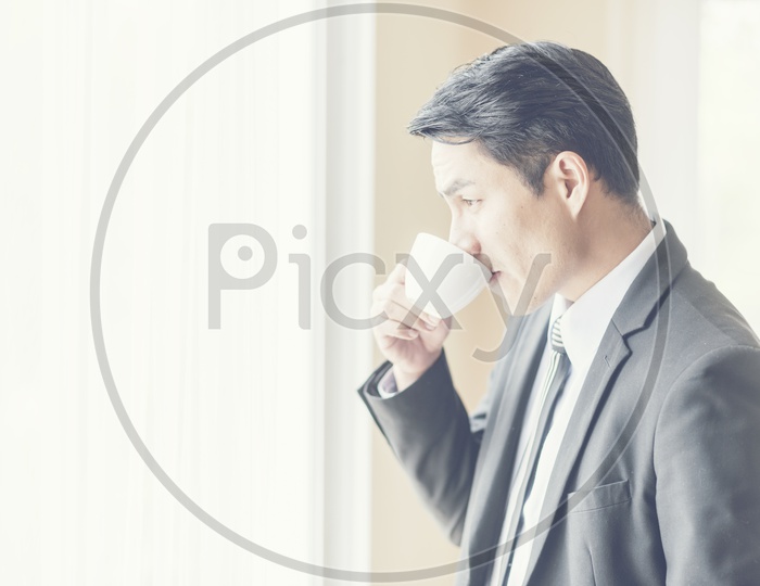 Asian CEO of a company drinking Coffee