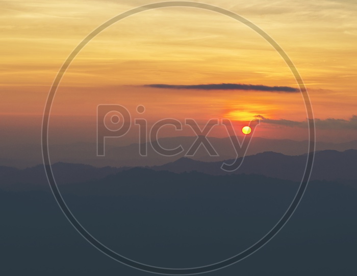 Landscape Of Sunset With Sun in Sky Over Mountains