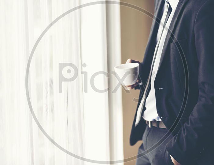 A businessman holding a coffee cup