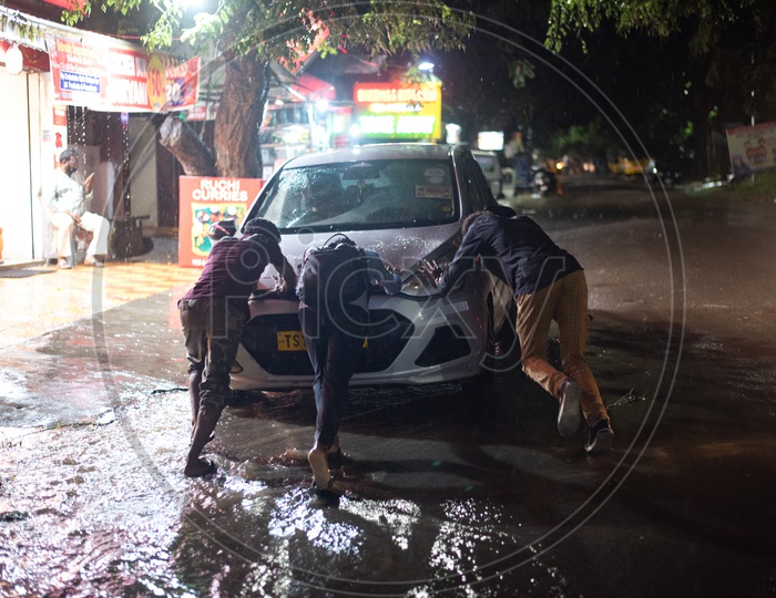 People Pushing A Break Downed Car Due to Heavy rain