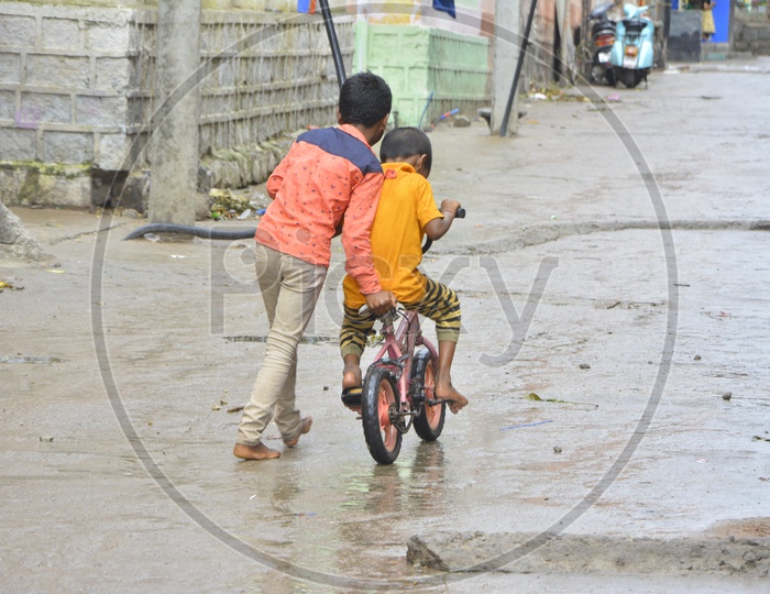Indian Siblings Elder Brother Helping Younger Brother in Riding Bicycle