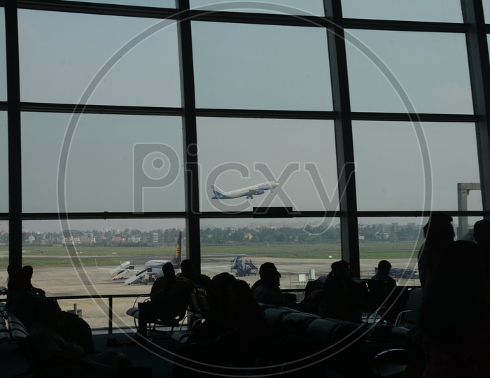 Silhouette Of Passengers Waiting At Lounge in Airport