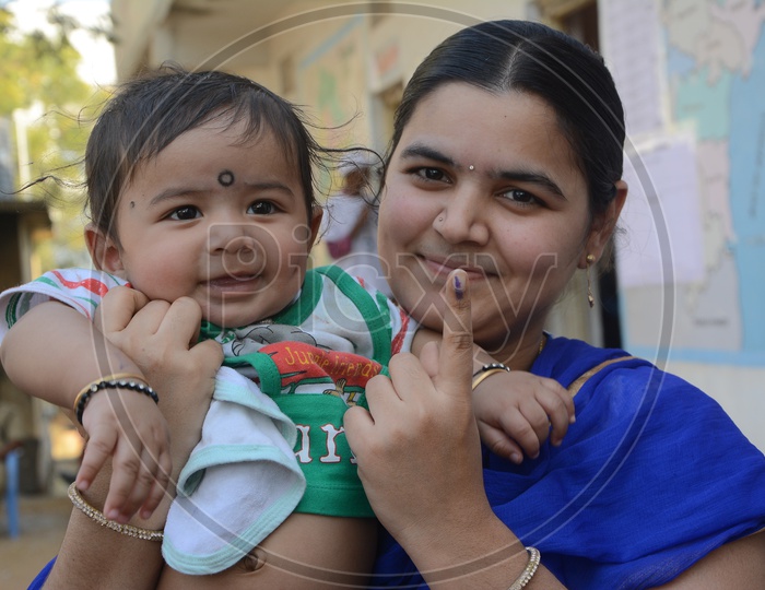 Young Woman  Voter Showing inked Finger Along With Her baby After Casting Her Vote in General Elections