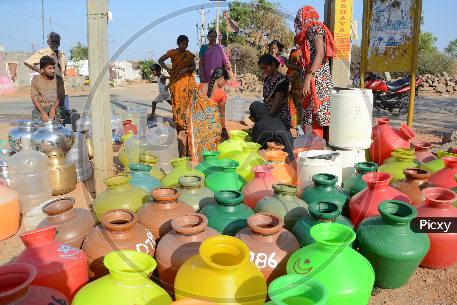 Indian Woman With Water Carrying Vessels At a drinking Water Pipeline in Water Crisis Areas of Hyderabad