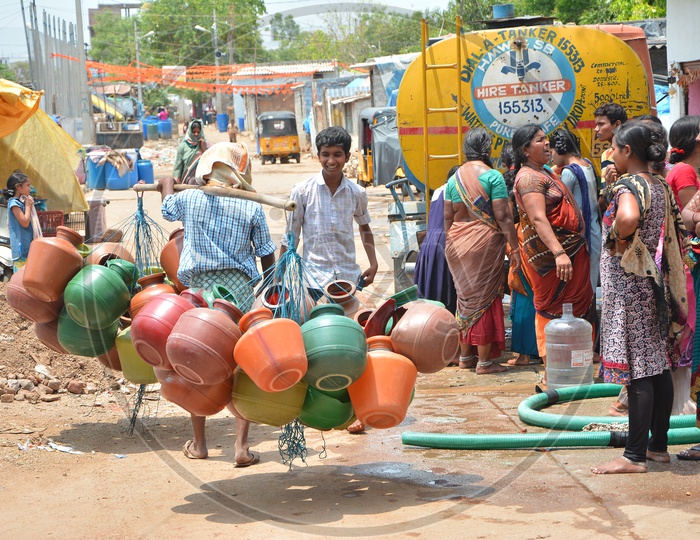 A Vendor Carrying Plastic Water Storage  Vessels on His Shoulder At Water Crisis Areas Of  Hyderabad City