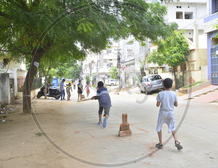 Indian Children Playing Cricket On The  Streets