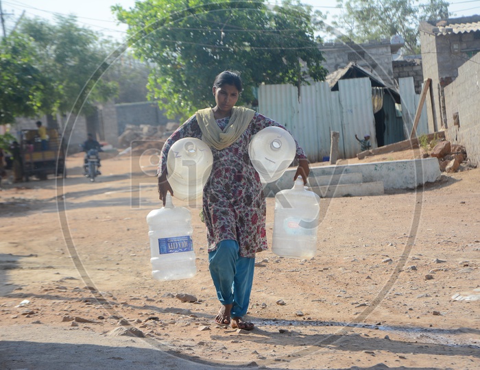 Woman  Carrying Water Storage Vessels For Drinking Water Storage in Water Crisis Areas of Hyderabad City