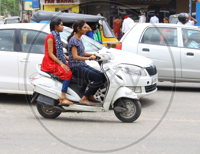 Young Indian Girls Riding Scooty Without Helmet Violating Traffic Rules