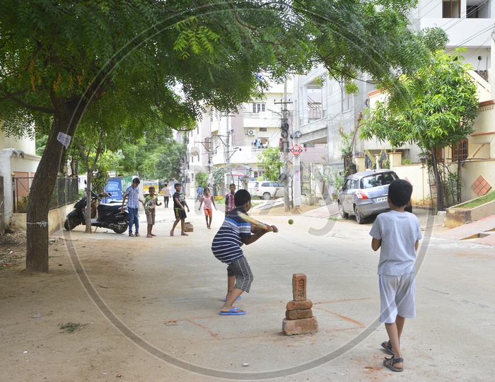 Indian Children Playing Cricket On The  Streets
