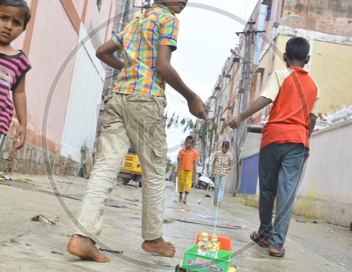 Indian Children Playing By Dragging Toy Cars On Streets