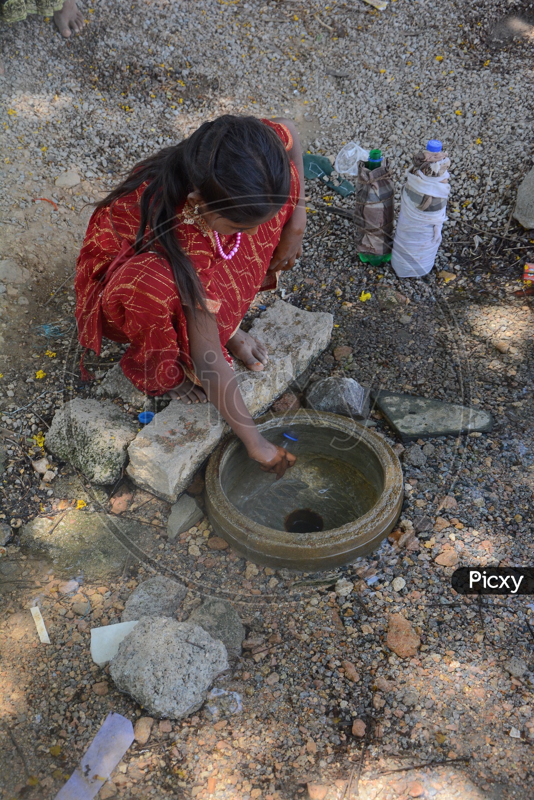 Young Girl Child  Filling  Drinking Water to Bottles From a Overflowing Pipeline In Hyderabad City