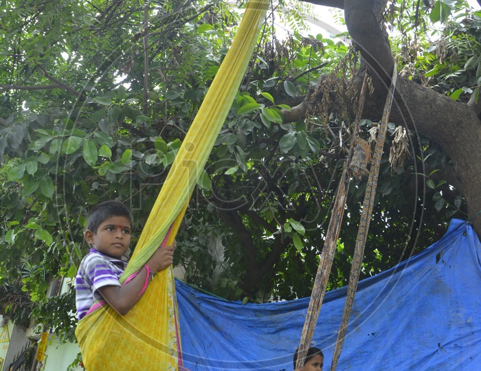 Indian  Children Playing With Swings  Tagged To trees