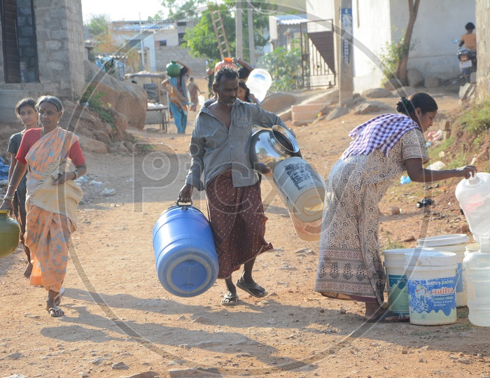 Woman Carrying drinking water in Plastic Vessels At Water Crisis Areas Of Hyderabad