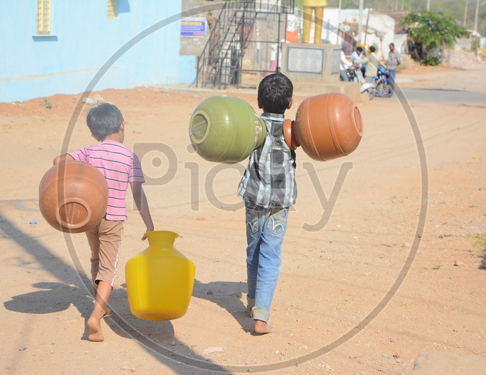 Young Children Carrying Water Storage Vessels For Drinking Water Storage in Water Crisis Areas of Hyderabad City