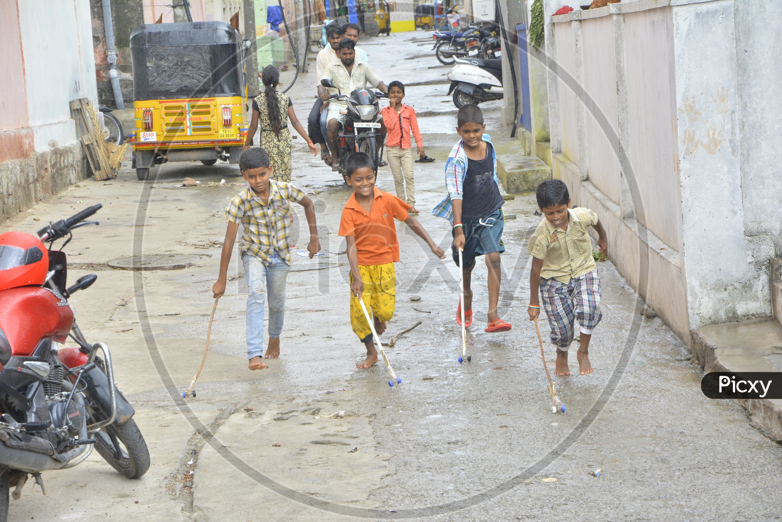Indian Children Playing With Rolling Wheels Made Of Bottle Cap and Wooden Sticks on Streets