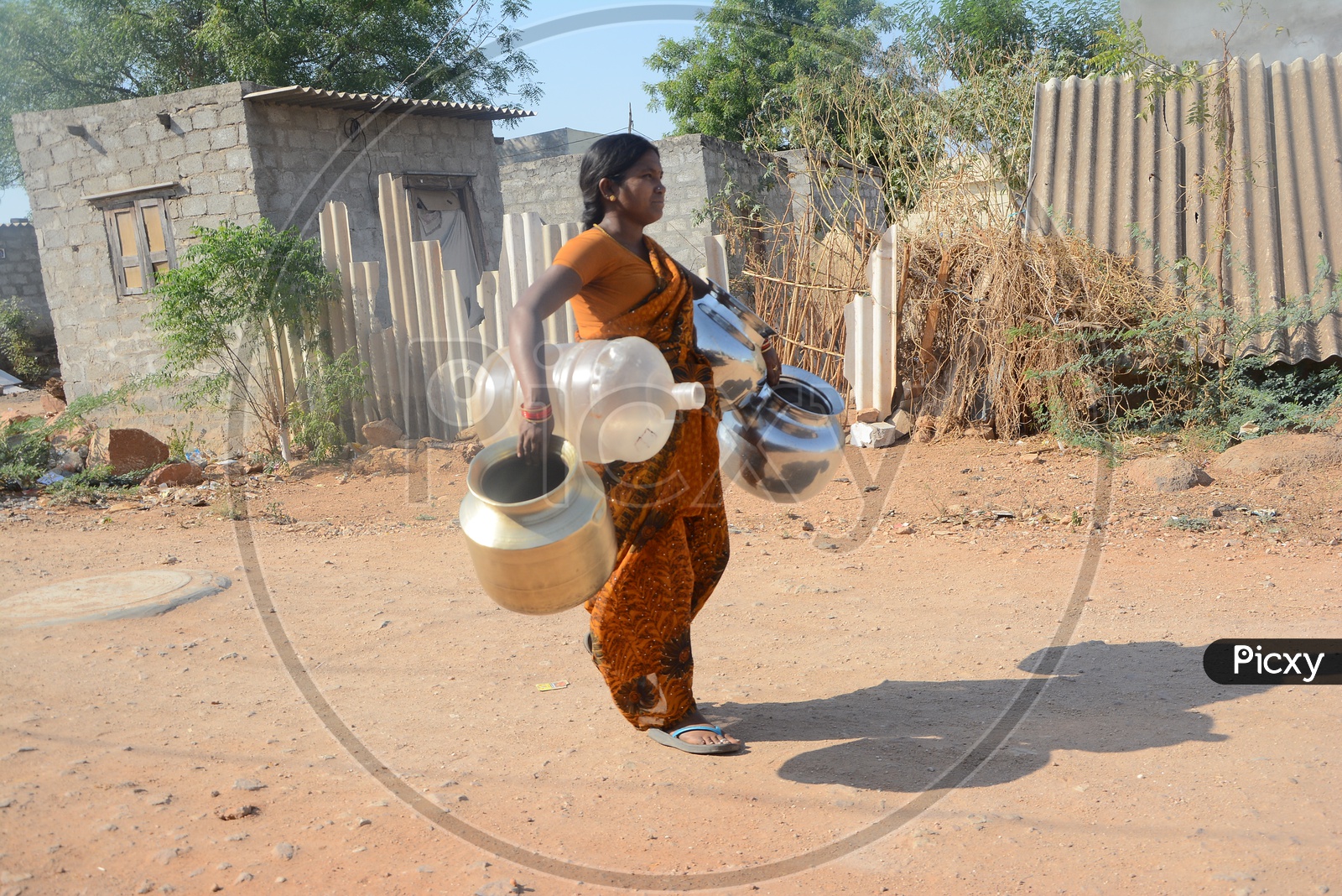 Woman  Carrying Water Storage Vessels For Drinking Water Storage in Water Crisis Areas of Hyderabad City
