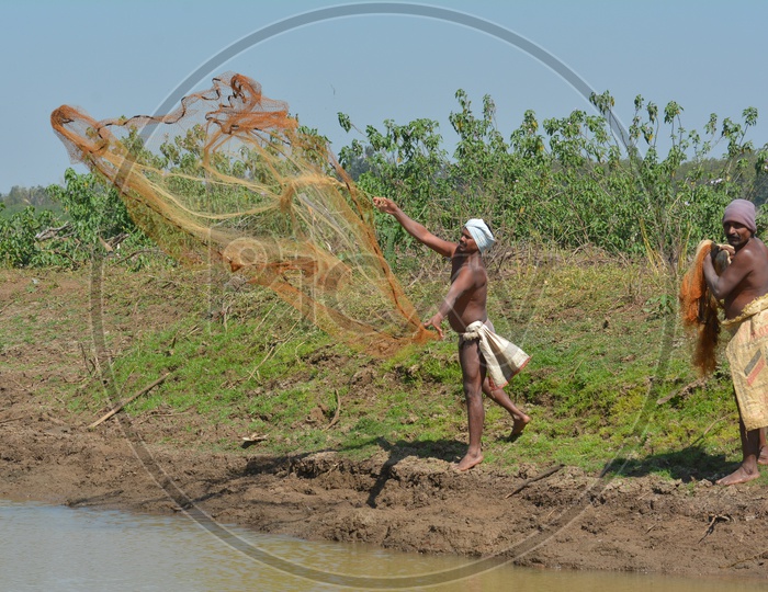 Telangana Local Fisherman Throwing Fishing Nets In Water Ponds