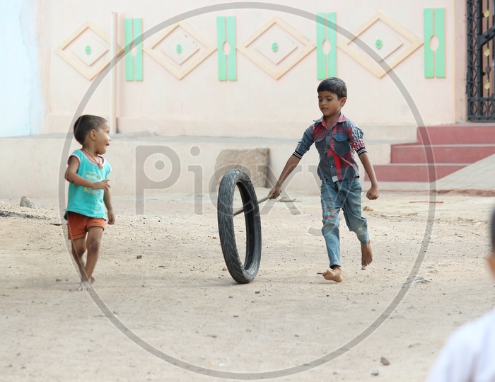 Indian Children Playing With Rubber Tyre On Streets